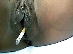 Fat black shiny pussy smoking a cigarette on webcam