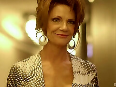 Lingerie-clad cougar with large fake bumpers sucking a big black cock