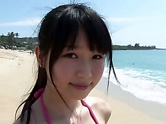 Slender Asian girl Tsukasa Arai ambles on a sandy beach under the sun