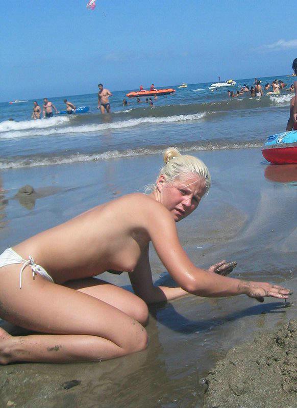 Young nudist friends naked together at the beach