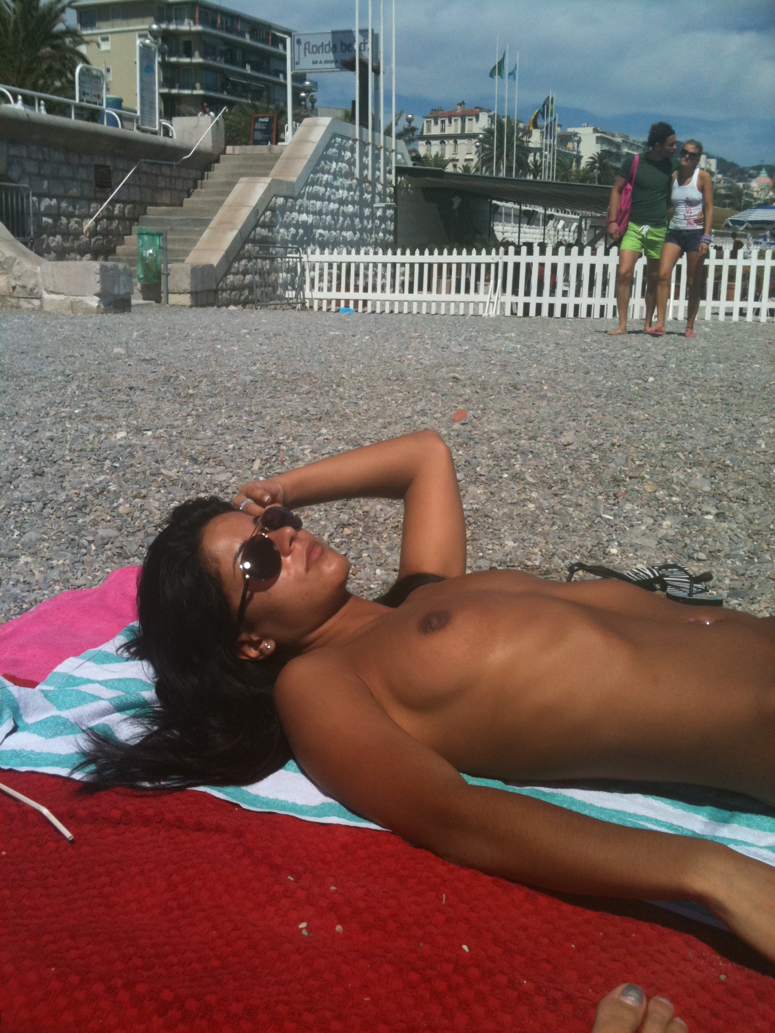 Beach voyeur shots of a suntanned Latina sunbathing topless