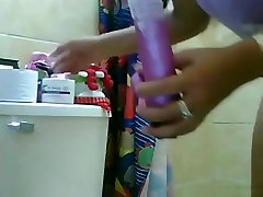 Big boobed girl lubes up a dildo and masturbates in the bathroom