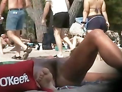 Hairy pussy sunbathing on the nudist beach and caught on cam