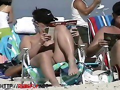 Couple split by Strangers on a velicity von short hair beach