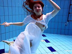 红发Marketa在一个白色的衣服在游泳池