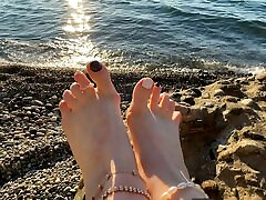 Mistress Lara plays with her av legend and toes on the beach